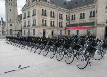 Devanture de la boutique, une cinquantaine de vélos bien rangés sur le parvis de la gare