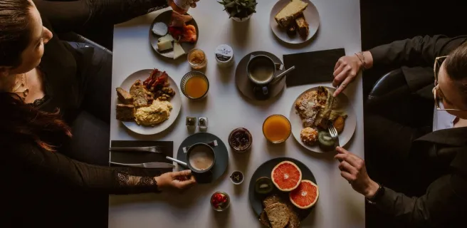 Deux femmes vues de dessus, en train de prendre un petit-déjeuner varié.