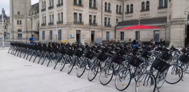Devanture de la boutique, une cinquantaine de vélos bien rangés sur le parvis de la gare