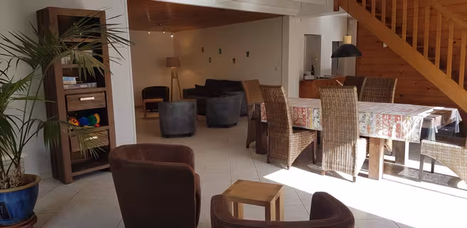 Grand salon/salle à manger avec escalier en bois menant à l'étage
